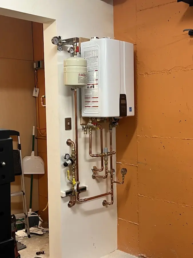 Plumbing technician inspecting water heater connections in Redland